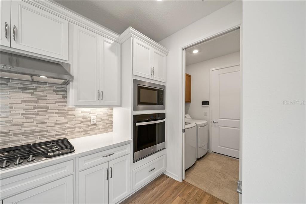 9434 Ballaster Pointe Loop Palmetto, FL 34221 - Photo 14 of 66 a kitchen with white cabinets and appliances