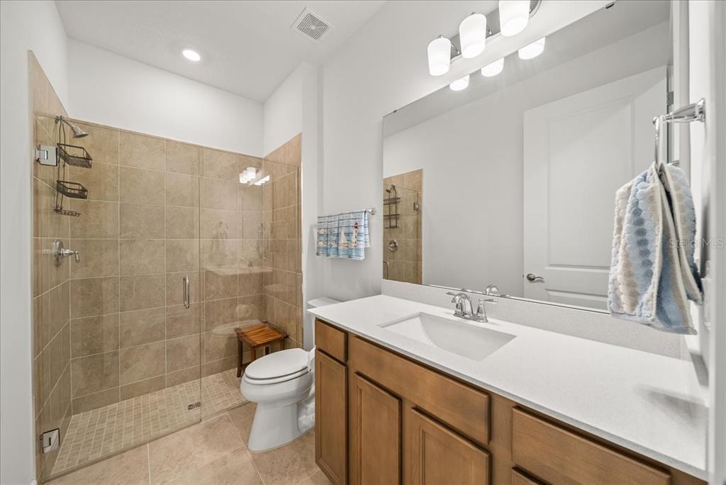 9434 Ballaster Pointe Loop Palmetto, FL 34221 - Photo 29 of 66 a bathroom with a granite countertop sink a toilet and shower