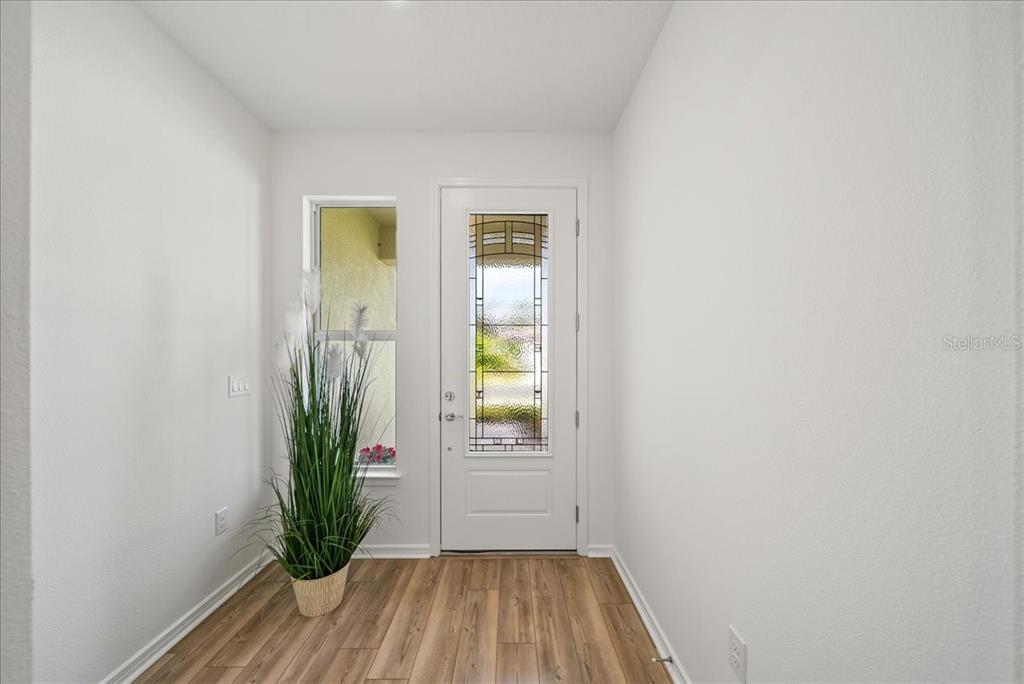 9434 Ballaster Pointe Loop Palmetto, FL 34221 - Photo 5 of 66 a view of a hallway with wooden floor and a bathroom