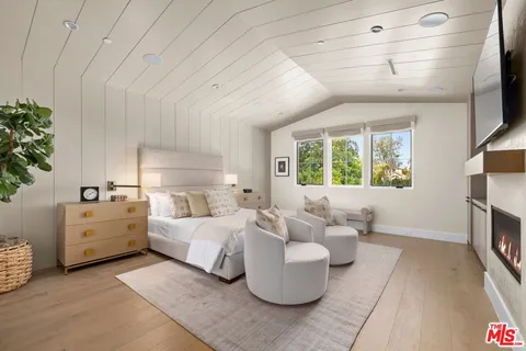 a bed room with furniture and a flat screen tv