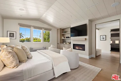 a bedroom with a large bed and a fireplace