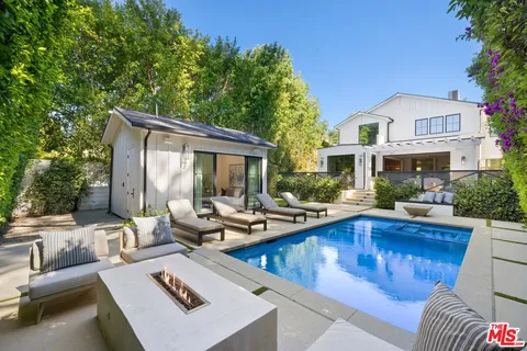 a view of a house with swimming pool and sitting area
