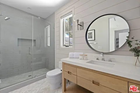 a bathroom with a sink a toilet and a mirror