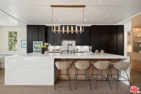 a kitchen with a sink and chairs