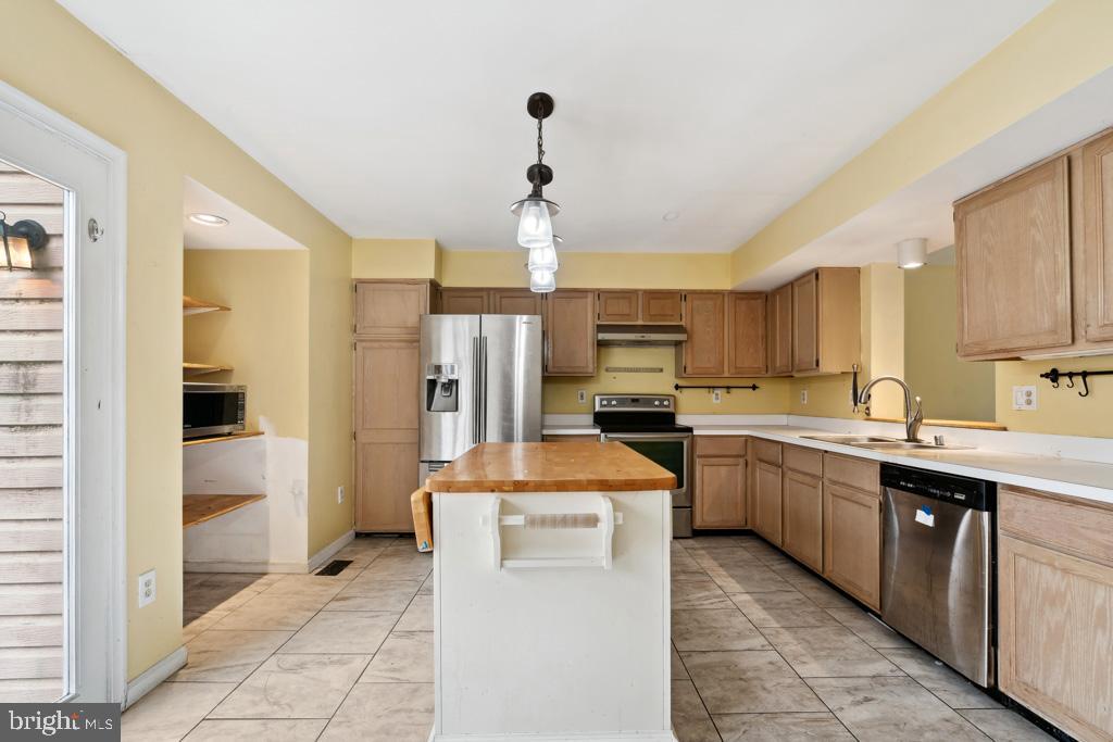 5235 Lightfoot Path Columbia, MD 21044 - Photo 7 of 32 a kitchen with stainless steel appliances a stove refrigerator sink and cabinets