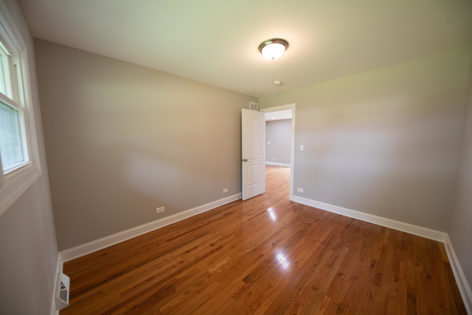 1722 East Aztec Lane Mount Prospect, IL 60056 - Photo 6 of 18 an empty room with wooden floor and windows
