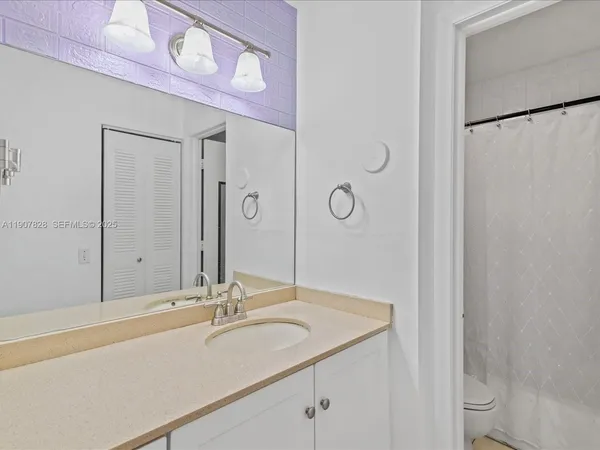 a bedroom with a bed and a flat tv screen on dresser