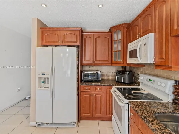 a kitchen with stainless steel appliances granite countertop a refrigerator stove and sink