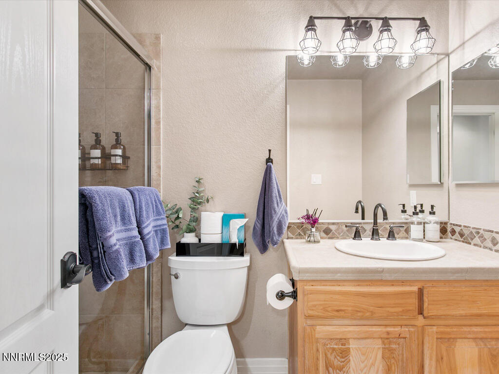 7284 Glenmore Court Reno, NV 89523 - Photo 20 of 28 a bathroom with a toilet sink and mirror