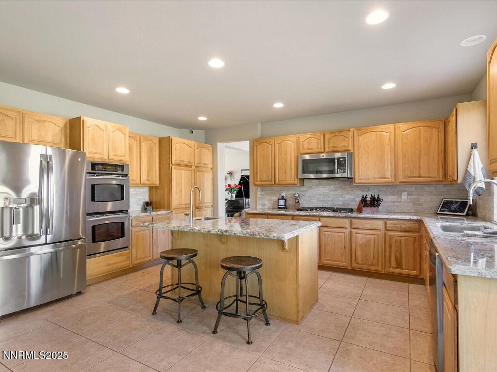7284 Glenmore Court Reno, NV 89523 - Photo 10 of 28 a kitchen with counter top space cabinets and stainless steel appliances