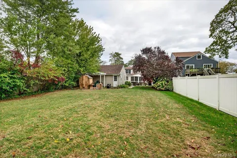 a view of a yard in front of a house with a large tree