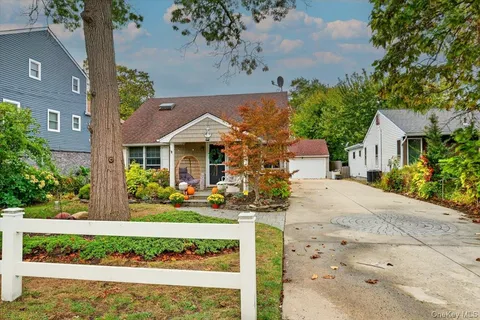 a front view of a house with a yard and potted plants