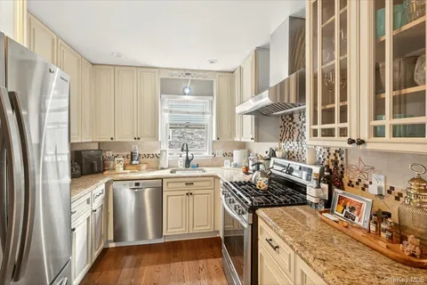 a kitchen with stainless steel appliances granite countertop a stove a sink and a refrigerator