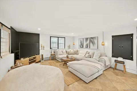 a living room with furniture a flat screen tv and large window