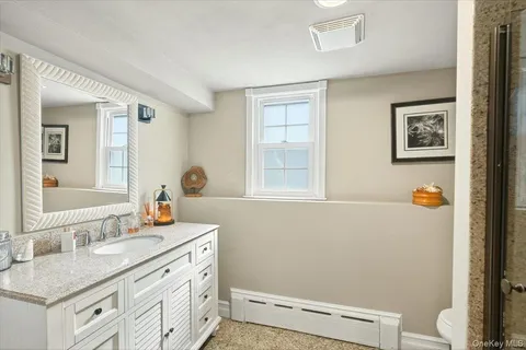 a bathroom with a sink a toilet and a mirror