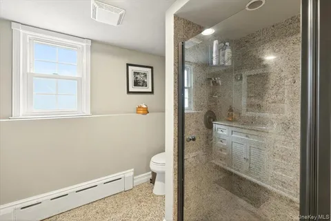a bathroom with a granite countertop sink a toilet and shower