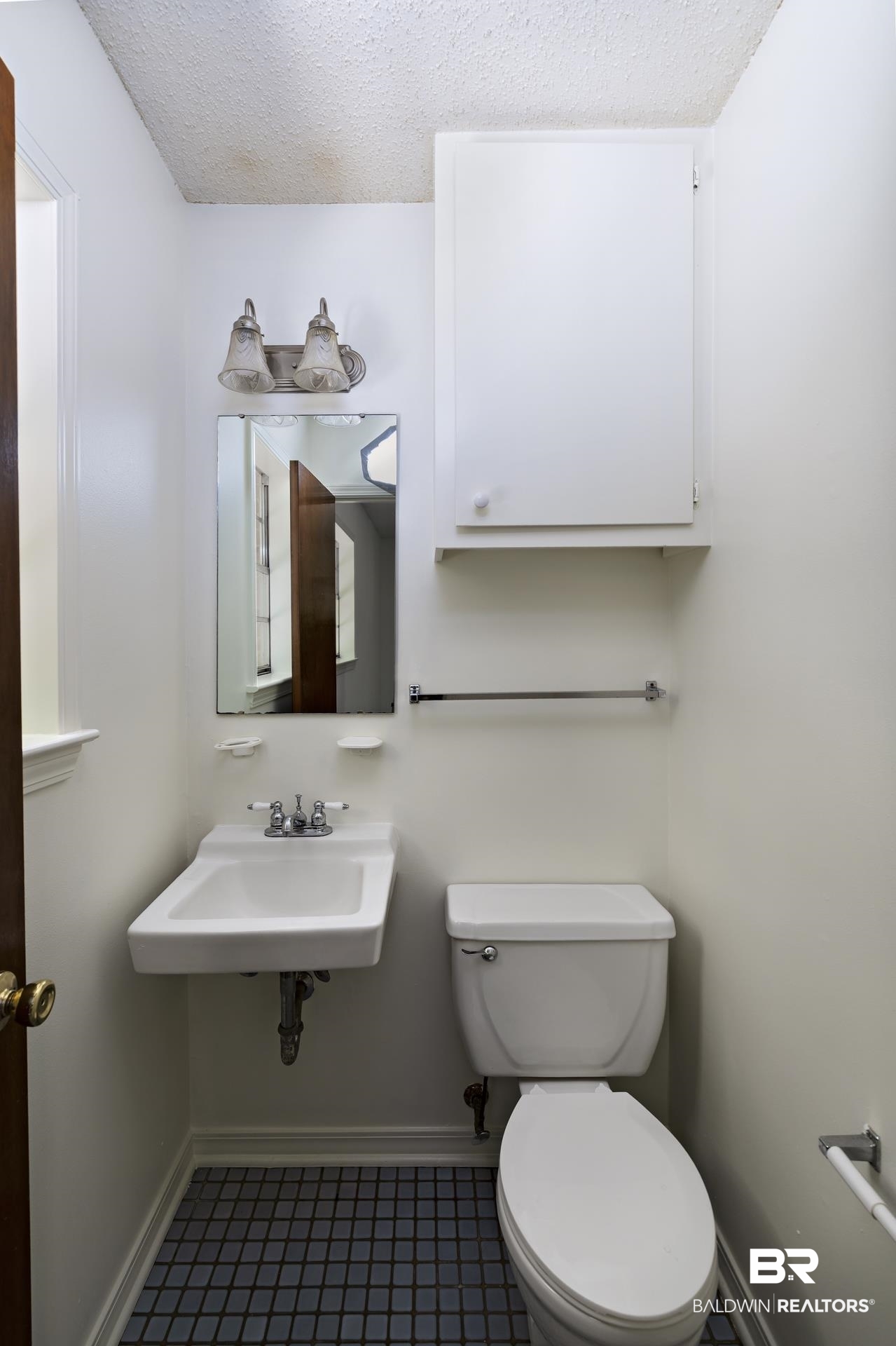 707 Johnson Avenue Fairhope, AL 36532 - Photo 36 of 38 Half bathroom featuring baseboards, tile patterned floors, a textured ceiling, toilet, and a sink