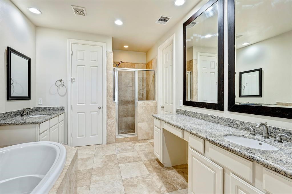 a spacious bathroom with a granite countertop tub sink shower and mirror
