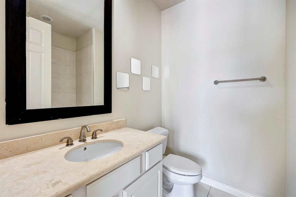 2514 Maxroy Street Houston, TX 77007 - Photo 5 of 21 a bathroom with a granite countertop sink a toilet and a mirror