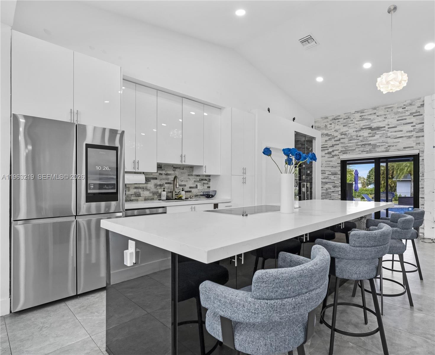 14651 Southwest 16th Street Davie, FL 33325 - Photo 14 of 52 a kitchen with a dining table chairs and refrigerator