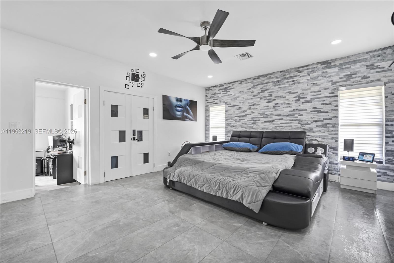 14651 Southwest 16th Street Davie, FL 33325 - Photo 22 of 52 a spacious bedroom with a bed a couch and a ceiling fan