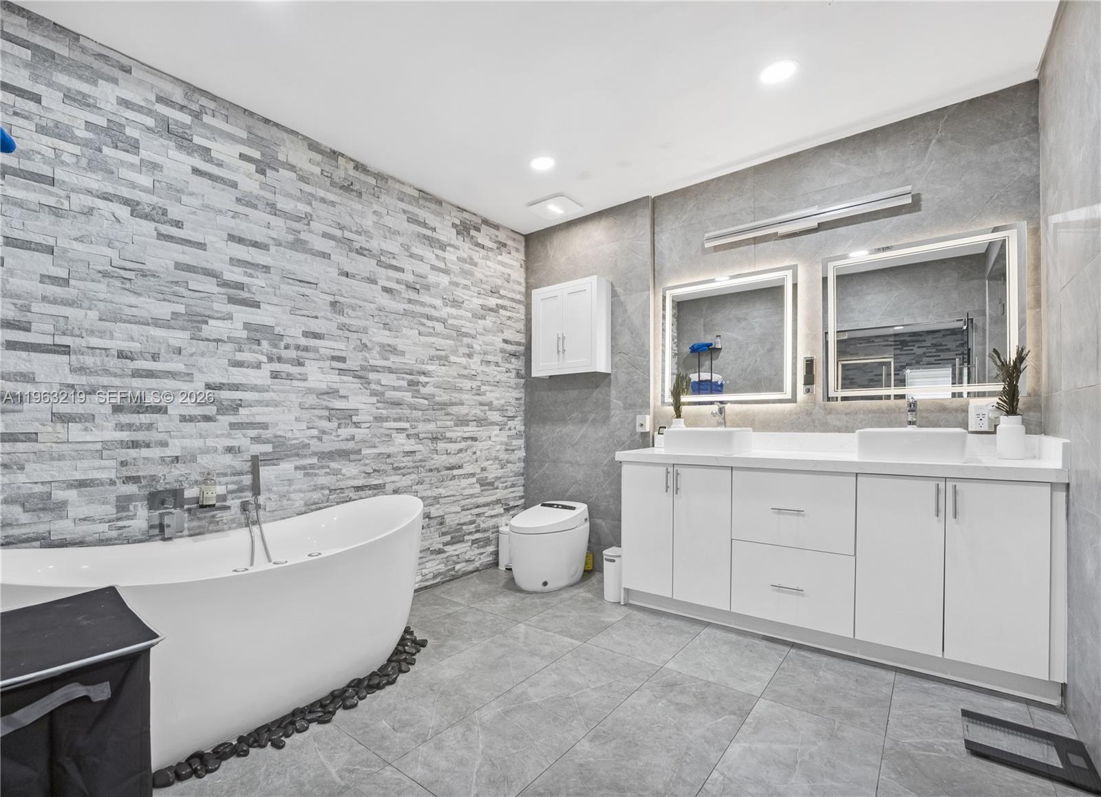 14651 Southwest 16th Street Davie, FL 33325 - Photo 27 of 52 a bathroom with a double vanity sink a mirror and a bathtub