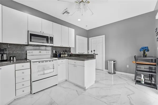 a view of kitchen with furniture and refrigerator