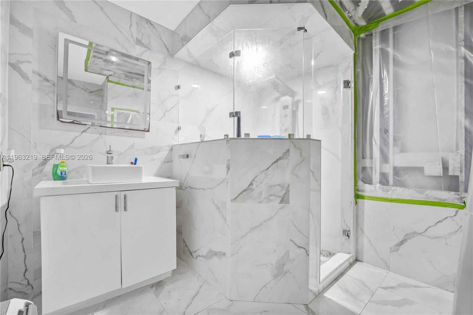 14651 Southwest 16th Street Davie, FL 33325 - Photo 39 of 52 a white bath tub sitting next to a bathroom sink and a mirror