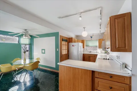 a kitchen with stainless steel appliances kitchen island granite countertop a sink and a refrigerator