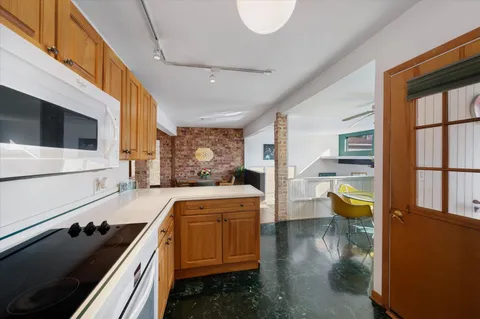 a kitchen that has a lot of cabinets a sink and wooden floor