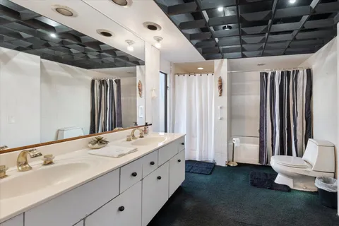 a spacious bathroom with a double vanity sink toilet and shower