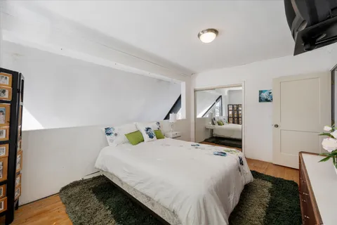 a bedroom with a bed and wooden floor