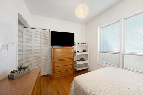 a bedroom with a bed and flat screen tv