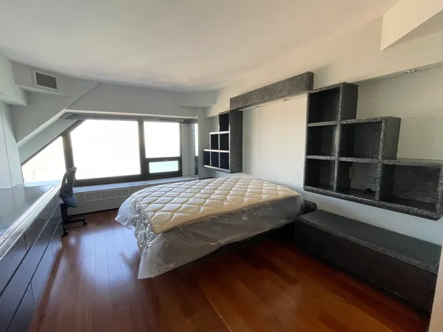 a bedroom with a bed and a large window