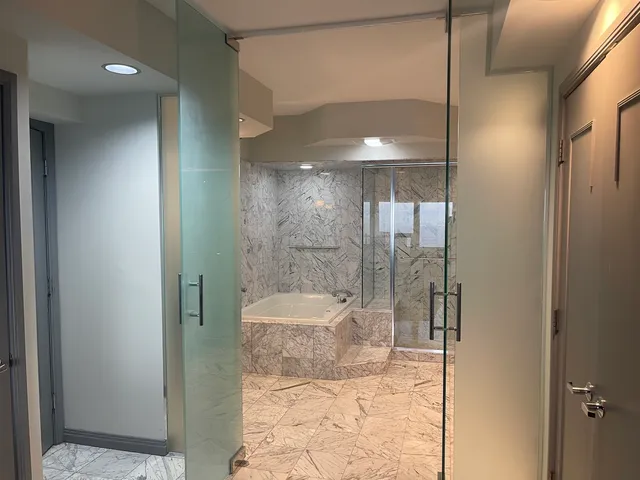 a bathroom with a granite countertop bathtub shower and toilet