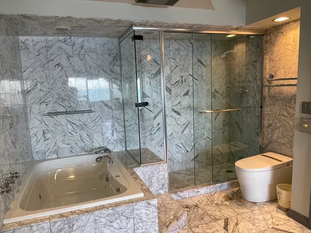 a bathroom with a tub shower and mirror