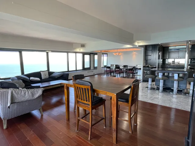 a living room with furniture a wooden floor and a large window