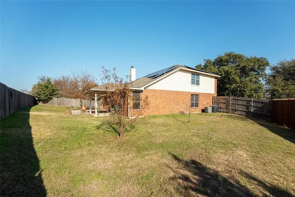 a view of a house with backyard and sitting area