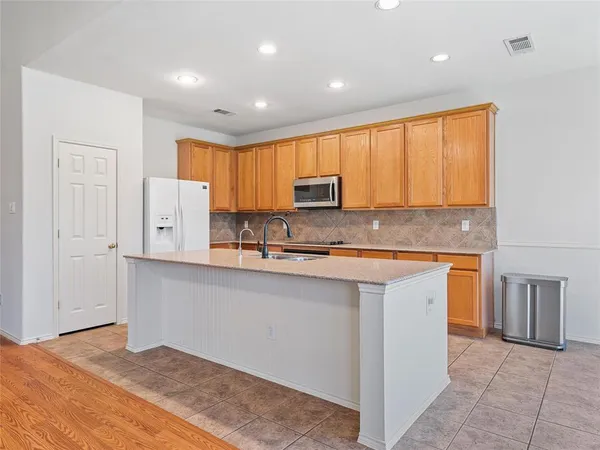 a kitchen with stainless steel appliances granite countertop a stove a sink and a microwave
