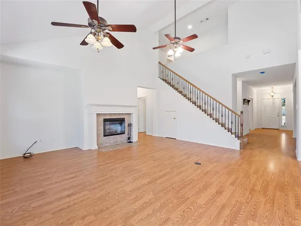 a view of an empty room and chandelier fan
