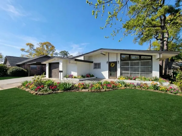 a front view of a house with a garden