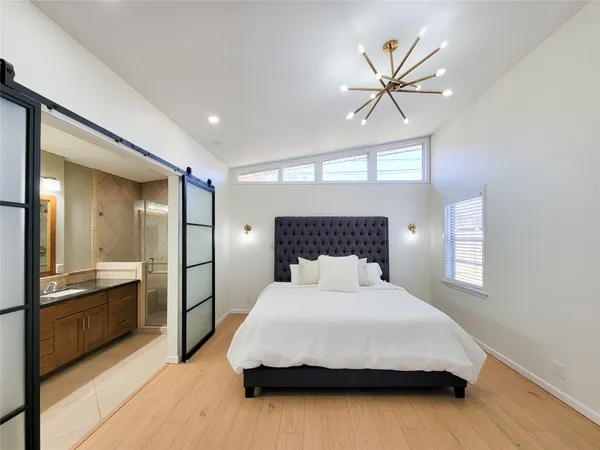 a bedroom with a large bed and a chandelier