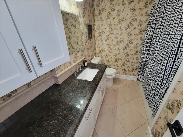 a bathroom with a granite countertop sink and a mirror