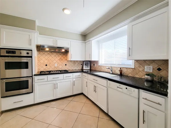 a kitchen with granite countertop white cabinets and white appliances