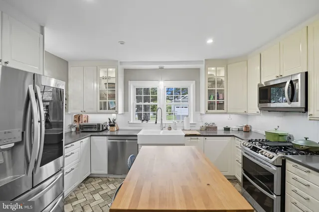 a bathroom with a granite countertop sink a toilet a mirror and shower