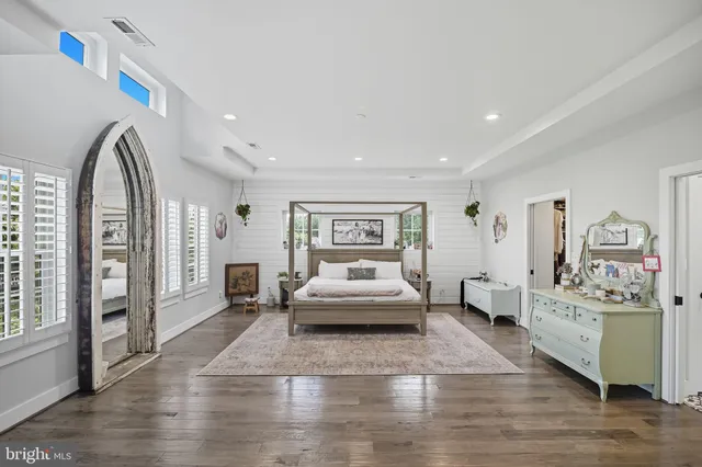a bedroom with a large bed and a flat tv screen on dresser