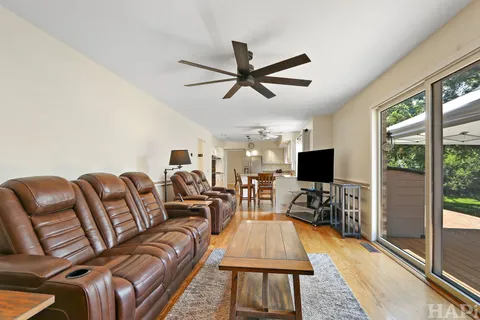 a living room with furniture a flat screen tv and a floor to ceiling window