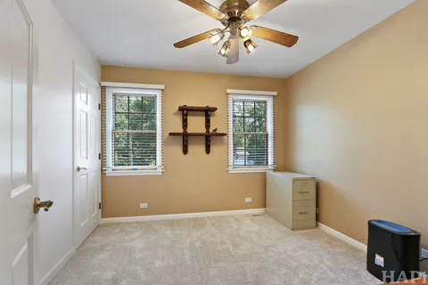an empty room with windows and fan