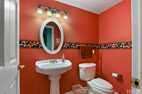 a bathroom with a toilet a sink and a mirror