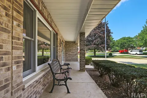 a view of a chair and tables in the patio of the house